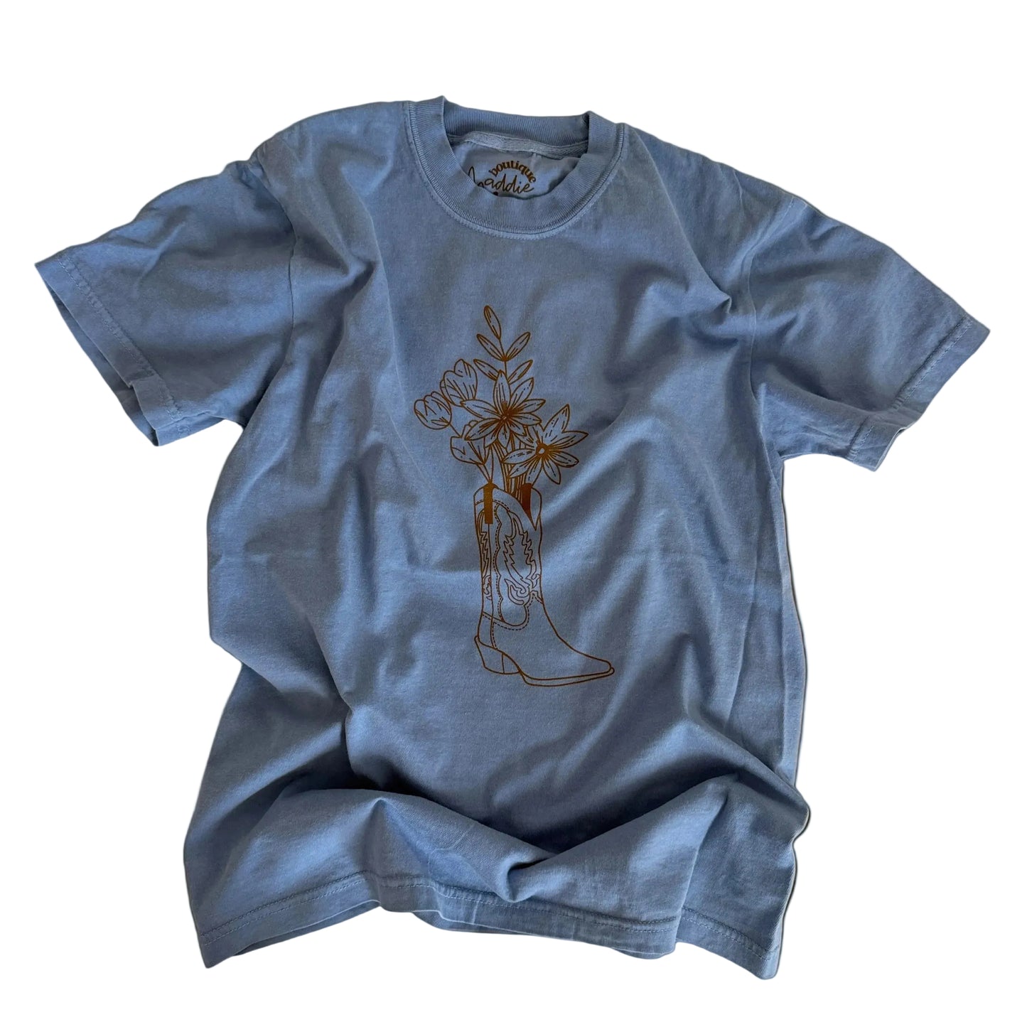 Blue t-shirt with a graphic design on a beige surface