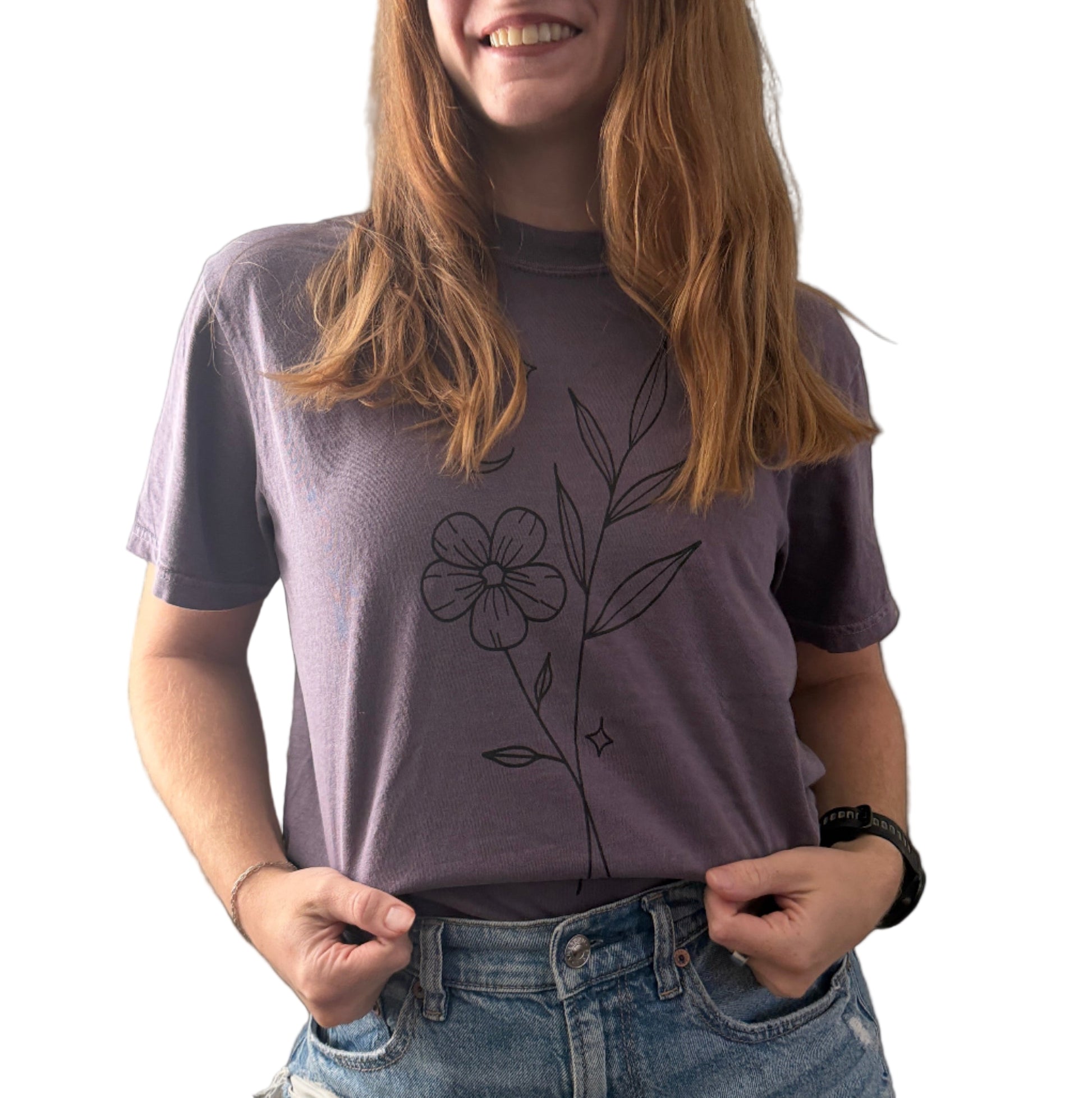 Person wearing a purple t-shirt with a floral design on a plain background